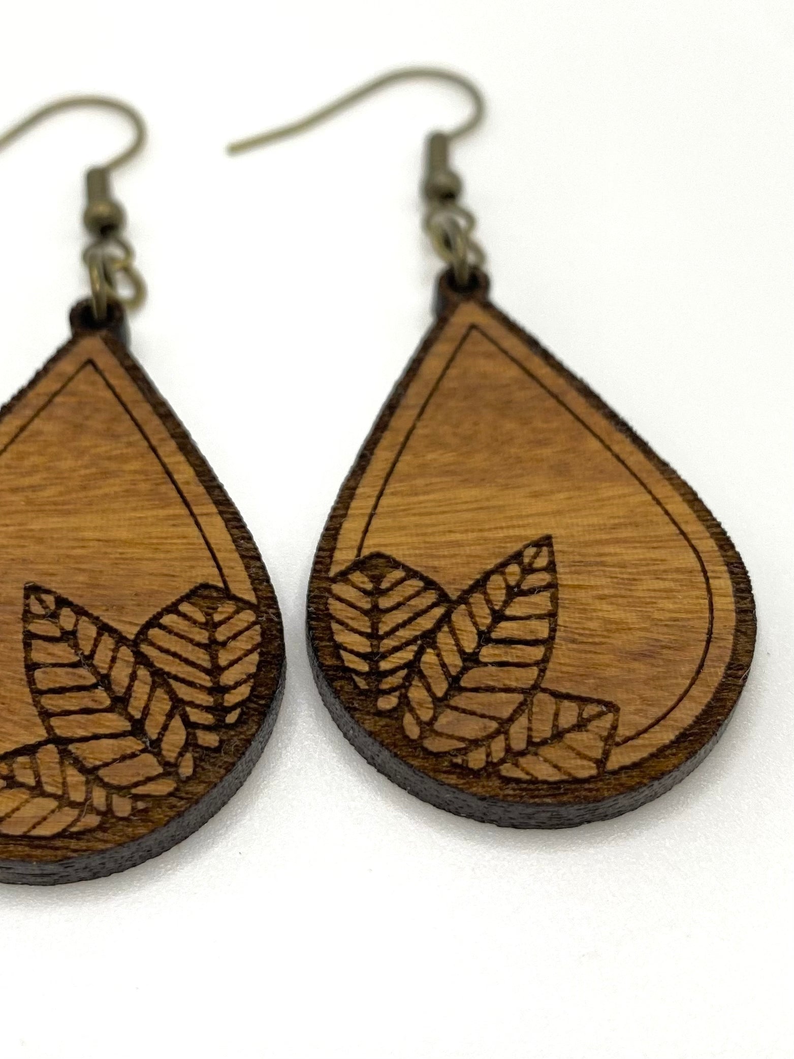 detail photo of leaf engrave on wood teardrop earrings