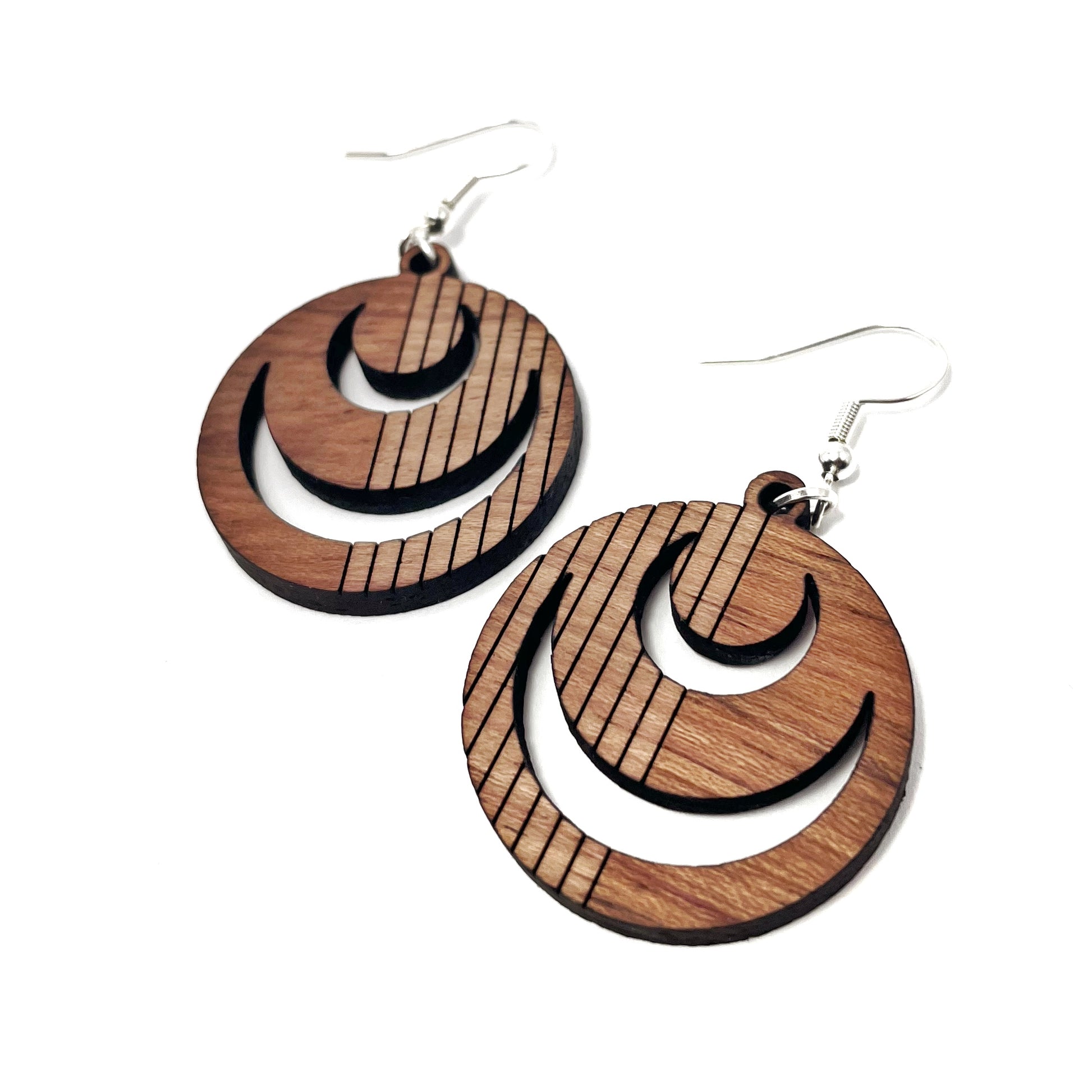 detail of round red wood earrings with moon holes